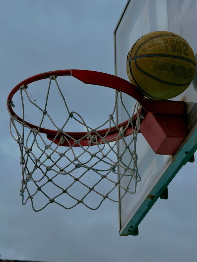Close-up of basketball about to enter the hoop against a cloudy sky. Captured in Veracruz, Mexico.